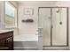 Modern bathroom boasts a glass-enclosed shower, a soaking tub, and stylish towel storage at 12887 N 93Rd Dr, Peoria, AZ 85381