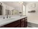 Bright bathroom featuring double sinks, a large mirror, and a soaking tub, offering a spa-like experience at 12887 N 93Rd Dr, Peoria, AZ 85381