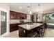 Beautiful kitchen featuring a granite island with seating and dark wood cabinets, ideal for modern living and entertaining at 12887 N 93Rd Dr, Peoria, AZ 85381