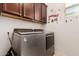 Efficient laundry room equipped with modern washer and dryer, along with storage cabinets at 12887 N 93Rd Dr, Peoria, AZ 85381