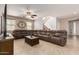 Cozy living room featuring a large sectional sofa, ceiling fan, and tiled floors, perfect for Gathering gatherings at 12887 N 93Rd Dr, Peoria, AZ 85381