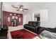 Cozy living room with plush seating, a ceiling fan, and an accent wall, creating an inviting and comfortable atmosphere at 12887 N 93Rd Dr, Peoria, AZ 85381