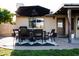 A furnished back patio features a brick floor and leads to a grassy backyard under a large black umbrella at 13219 N 46Th Pl, Phoenix, AZ 85032
