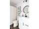 Clean and updated bathroom with decorative cactus prints, a round mirror and wood look floors at 13219 N 46Th Pl, Phoenix, AZ 85032