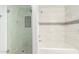 Bathroom featuring a glass shower door and a tub with decorative tile surround at 13616 N 41 Pl, Phoenix, AZ 85032
