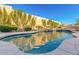 View of the backyard pool with waterfall feature and desert landscaping providing privacy and beauty at 14808 E Miramonte Way, Fountain Hills, AZ 85268