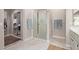 Bright bathroom featuring a shower and a large mirror at 15481 W Amelia Dr, Goodyear, AZ 85395