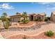 Beautiful single-story home with desert landscaping featuring rocks, cactus, and palm trees at 15481 W Amelia Dr, Goodyear, AZ 85395