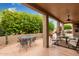 Inviting covered patio with comfortable seating, perfect for outdoor dining and entertaining with lush greenery at 15481 W Amelia Dr, Goodyear, AZ 85395