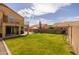Beautiful backyard featuring a well-manicured lawn, covered patio, and mature trees, creating a serene outdoor space at 1648 S Faith --, Mesa, AZ 85209