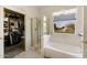Bright bathroom featuring a shower, closet, bathtub, and large window with outdoor views at 1648 S Faith --, Mesa, AZ 85209