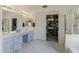 Bright bathroom featuring double sinks, white marble floors, and a walk-in closet with ample storage at 1648 S Faith --, Mesa, AZ 85209