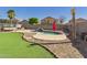 Backyard with rock waterfall pool, artificial grass, and desert landscaping at 1677 E Heather Dr, San Tan Valley, AZ 85140