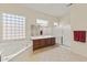 Bright bathroom features a soaking tub, glass block window, double sink vanity, and tiled floors at 16927 W Desert Blossom Way, Surprise, AZ 85387