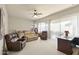 Bright bedroom with neutral carpet, ceiling fan and multiple seating areas at 16927 W Desert Blossom Way, Surprise, AZ 85387