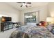 Bedroom features a ceiling fan and sliding glass doors that open to a covered patio area at 16927 W Desert Blossom Way, Surprise, AZ 85387