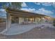 Extended covered patio with ample space for seating and entertaining, complete with desert landscape and rock features at 16927 W Desert Blossom Way, Surprise, AZ 85387