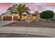 Inviting single-story home with well-maintained landscaping, desert accents, and a charming entryway with a beautiful palm tree at 16927 W Desert Blossom Way, Surprise, AZ 85387