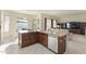 Kitchen island with sink and stainless steel dishwasher, seamlessly flowing into the living area at 16927 W Desert Blossom Way, Surprise, AZ 85387