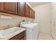 The laundry room features a sink and cabinetry above the washer and dryer, offering convenience and storage at 16927 W Desert Blossom Way, Surprise, AZ 85387