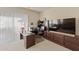 Well-lit office space with custom built-ins, a large desk, and natural light from vertical blinds at 16927 W Desert Blossom Way, Surprise, AZ 85387