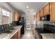 Galley kitchen featuring granite countertops, mosaic backsplash, and wood cabinets at 1811 S 39Th St # 29, Mesa, AZ 85206