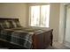 Bedroom with plaid bedding, wood frame, and access to balcony at 18416 N Cave Creek Rd # 1053, Phoenix, AZ 85032
