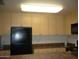 Kitchen with light cabinets, dark countertops, black refrigerator and microwave at 18416 N Cave Creek Rd # 1053, Phoenix, AZ 85032