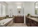 Bright bathroom featuring a bathtub, wooden cabinets and decorated walls at 18552 N 94Th St, Scottsdale, AZ 85255