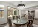 Elegant dining room with glass table, designer chairs, modern chandelier, and access to the outdoor patio at 18552 N 94Th St, Scottsdale, AZ 85255