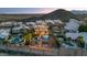 Stunning aerial view of a backyard oasis featuring a pool, putting green, and cozy fire pit area against a mountain backdrop at 1922 E Saltsage Dr, Phoenix, AZ 85048