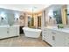 Elegant bathroom features a soaking tub, dual vanities, stylish lighting, and tile flooring at 1922 E Saltsage Dr, Phoenix, AZ 85048