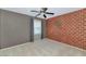 Comfortable bedroom with unique brick accent wall, ceiling fan, and carpeted floor at 1922 E Saltsage Dr, Phoenix, AZ 85048
