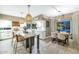 An open kitchen flows into dining area with view of the pool, with a large island and modern pendant lights at 1922 E Saltsage Dr, Phoenix, AZ 85048