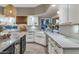 Well-lit kitchen featuring white cabinets, farmhouse sink, stone countertops and light wood-look flooring at 1922 E Saltsage Dr, Phoenix, AZ 85048