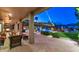 Covered patio featuring stone flooring, a cozy fireplace, and a view of the pool with waterfall and landscape at 1922 E Saltsage Dr, Phoenix, AZ 85048