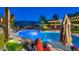 Serene pool area with a rock waterfall feature, mature landscaping, and cozy lounge chairs for relaxation at 1922 E Saltsage Dr, Phoenix, AZ 85048