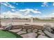 Backyard fire pit area with decorative stonework and artificial turf, offering a cozy outdoor space at 2535 N Pinnule Cir, Mesa, AZ 85215