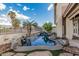 Serene backyard featuring a rock-lined pool with waterfall, palm trees, and manicured landscaping at 2535 N Pinnule Cir, Mesa, AZ 85215