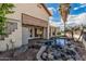 Lush backyard with a stone-lined pond, mature palm trees, and a charming water feature at 2535 N Pinnule Cir, Mesa, AZ 85215