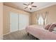 Comfortable carpeted bedroom with ceiling fan and sliding-door closet at 2535 N Pinnule Cir, Mesa, AZ 85215