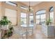 Bright breakfast nook with a glass table, white wicker furniture, and ample natural light from surrounding windows at 2535 N Pinnule Cir, Mesa, AZ 85215