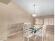 Dining room with glass-topped table, six chairs, neutral walls, tile flooring, and decorative chandelier at 2535 N Pinnule Cir, Mesa, AZ 85215