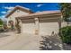 Beige two-car garage with a tile roof, set in desert landscaping with a lovely rose bush and shade tree at 2535 N Pinnule Cir, Mesa, AZ 85215