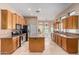 Open kitchen featuring a central island, wooden cabinetry, and seamless flow to the breakfast nook at 2535 N Pinnule Cir, Mesa, AZ 85215