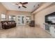 Bright living room featuring tiled floors, neutral walls, glass patio door, a ceiling fan, and comfortable seating at 2535 N Pinnule Cir, Mesa, AZ 85215