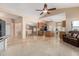 Bright and airy living room with tiled floors, neutral paint, and an open layout to the dining and kitchen at 2535 N Pinnule Cir, Mesa, AZ 85215