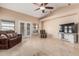 Comfortable living room with neutral tones, tile flooring, a ceiling fan, and patio access at 2535 N Pinnule Cir, Mesa, AZ 85215