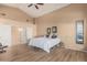 Bright main bedroom with high ceilings, laminate floors, and closet entrances at 2535 N Pinnule Cir, Mesa, AZ 85215