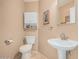 Cozy powder room with pedestal sink, toilet, and decorative wall accents at 2535 N Pinnule Cir, Mesa, AZ 85215